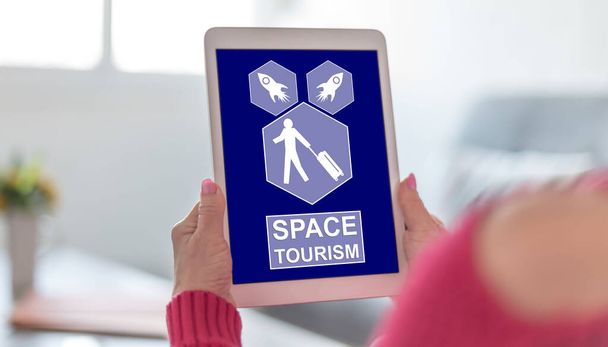 Οθόνη tablet που εμφανίζει μια έννοια διαστημικού τουρισμού - Φωτογραφία, εικόνα