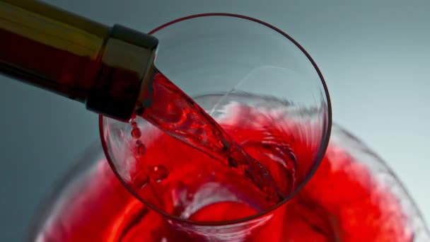 A vörösborpatak üvegárukat öntött a palack nyakából. Merlot ital töltő decanter lassított felvétel. Rózsa alkohol ital fröccsenő tiszta tál. Intoxikus folyadéksugaras feltöltő átlátszó tartály - Felvétel, videó