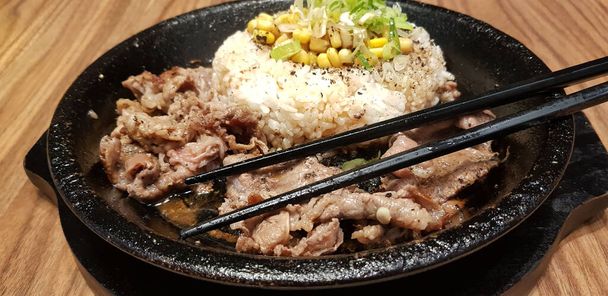 foco seletivo bife grelhado com molho coreano bulgogi em cima de arroz com fatia de pimenta e milho doce estilo alimentar coreano - Foto, Imagem