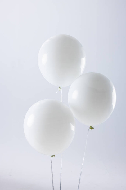 Composition of close up of new years balloons on white background. New year's eve party, celebration and copy space concept. - Photo, Image