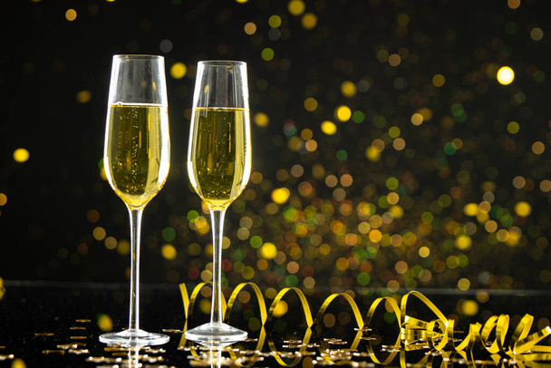 Composition of close up of new years champagne with confetti on black background. New year's eve party, celebration and copy space concept. - Фото, зображення