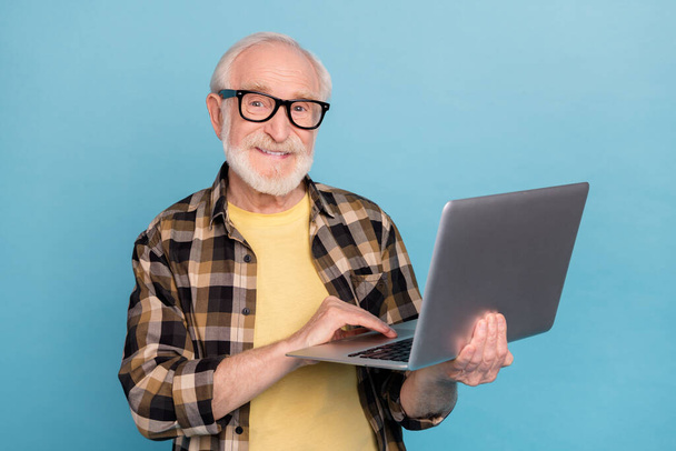 Photo of funny sweet man pensioner dressed checkered shirt eyewear communicating modern gadget isolated blue color background. - Φωτογραφία, εικόνα