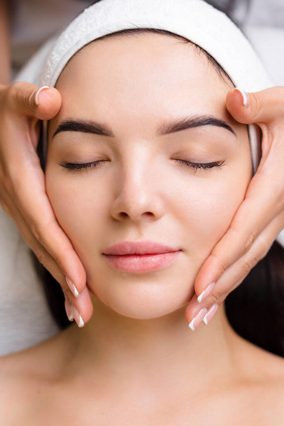 Professional anti-aging facial massage. Action. Relaxing facial treatment at Spa. Relaxing and rejuvenating facial massage for women.  - Foto, Imagen