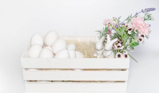 White colored heart in front and white eggs and blurred flowers in the background Easter or food concept - Photo, Image