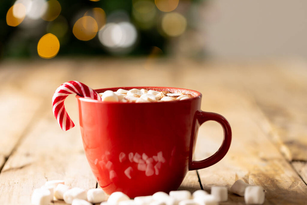 Image of red cup with hot chocolate and marshmallows and copy space over christmas tree. Christmas, tradition and celebration concept. - Fotografie, Obrázek