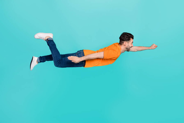 Profile side full length photo of excited guy fly ahead feel inspiration isolated on cyan color background. - Фото, зображення