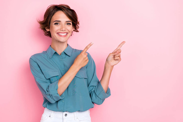 Portrait photo of young adorable cute nice woman wear blue shirt toothy beaming directing fingers empty space cool new clinic whitening prices isolated on pink color background. - 写真・画像