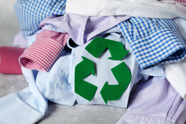 A pile of used clothes on the floor. Recycling of clothes. Ecological and sustainable lifestyle. High quality photo - Фото, изображение