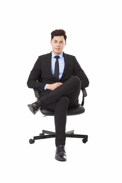 Nuori liikemies istuu tuolissa
 - Valokuva, kuva