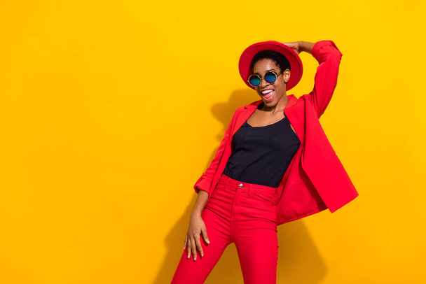 Photo of funny pretty short hair person dressed red suit cap dark spectacles dancing isolated yellow color background. - Fotografie, Obrázek