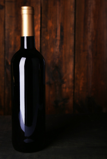 Bottle of red wine on wooden background - Photo, image