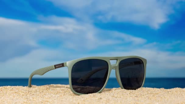 Eine Sonnenbrille am Strand mit vorbeiziehenden Wolken  - Filmmaterial, Video