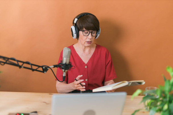 Портрет зрелой женщины в наушниках и беседах на онлайн радиостанции - подкаст и трансляция - Фото, изображение