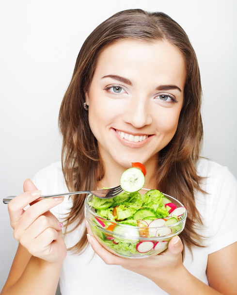 Menina com uma salada em um fundo branco
 - Foto, Imagem