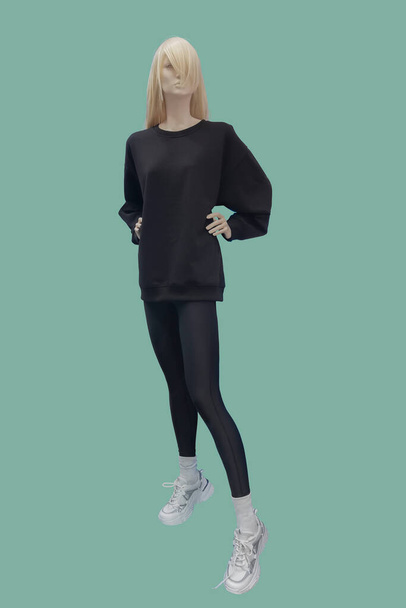 Full length image of a female display mannequin wearing sportswear isolated on green background - Photo, Image