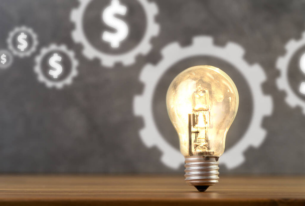 Feche a foto do sinal do dólar e da lâmpada brilhante em um quadro como um símbolo da inicialização, investindo dinheiro, alvo e ideia de negócio. - Foto, Imagem