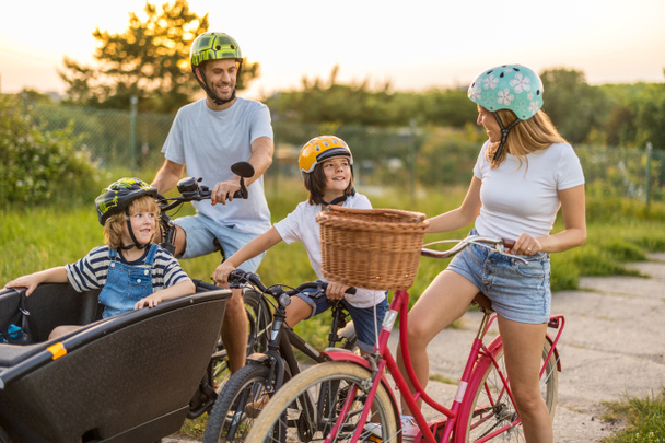 Familia feliz en bicicleta juntos en el campo - Foto, imagen
