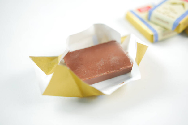 cukorka csokoládé egy papír csomag fehér , - Fotó, kép