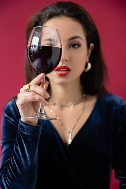 elegáns nő elhomályosítja arc üveg bor elszigetelt piros - Fotó, kép