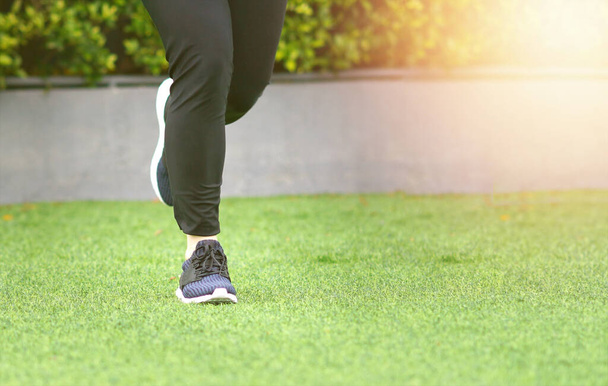 Nainen yllään urheilukengät lenkkeily ajaa nurmikolla - Valokuva, kuva