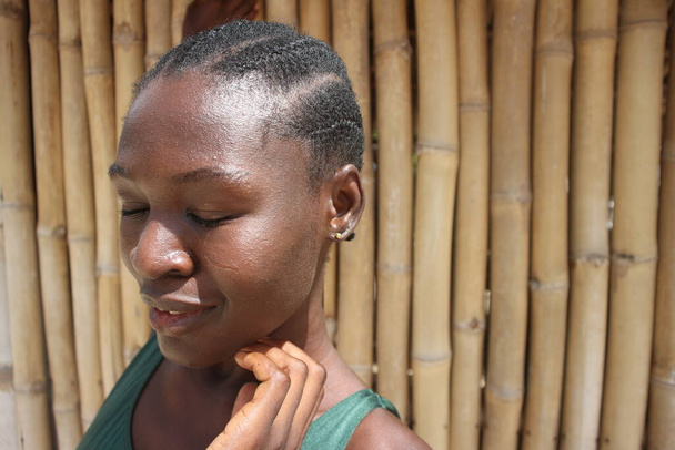 Cheveux et peau naturels African Woman gros plan headshot bambou fond peau foncée - Photo, image