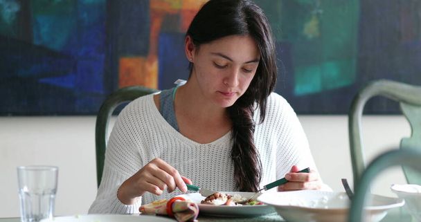 Woman in 30s eating lunch. Casual candid girl eats meal at home - Foto, Imagem