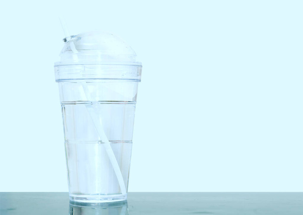 пластикова чашка з водою і соломою
 - Фото, зображення