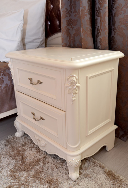 Bedside table of color of an ivory in a bedroom. Modern classics - Φωτογραφία, εικόνα