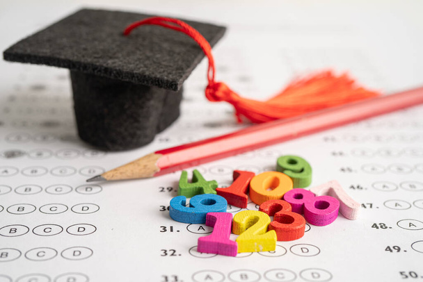 Matemáticas Número colorido con sombrero de graduación y lápiz en la hoja de respuestas fondo, Educación matemáticas aprendizaje enseñar concepto. - Foto, Imagen