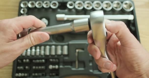 O mecânico desconecta a chave de catraca do suporte do soquete de metal. Demonstração de trabalho, vista superior, close-up. Imagens 4k de alta qualidade - Filmagem, Vídeo