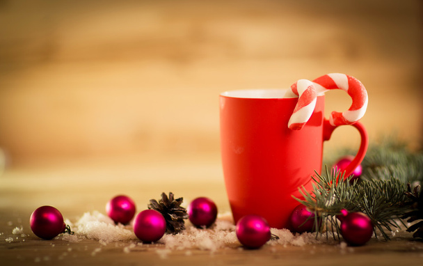 Christmas mug with decorations and sweets on wooden background - Фото, изображение