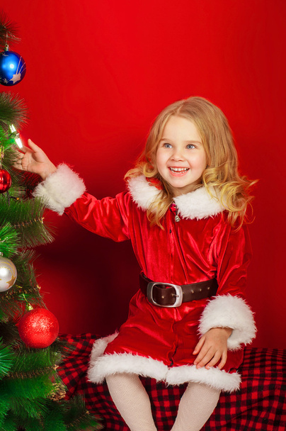 Little girl near the Christmas tree - 写真・画像
