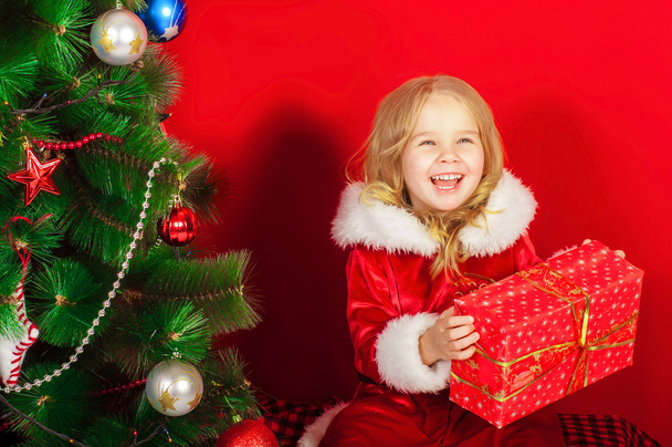 Little girl near the Christmas tree - Fotografie, Obrázek