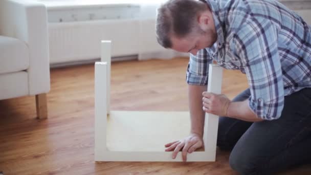 Close up van mannelijke handen montage benen aan tabel - Video