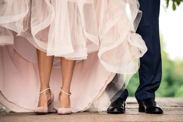 pernas bonitas de uma menina de sapatos ficar ao lado das pernas de um homem de calças - Foto, Imagem