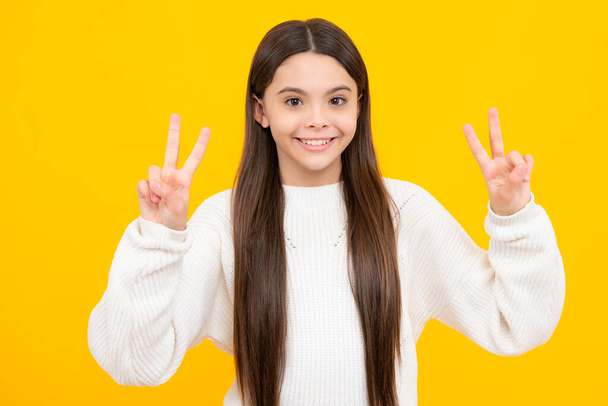 Χαριτωμένη έφηβη που δείχνει τα δάχτυλα της νίκης. Νούμερο δύο, v σημάδι, ειρήνη δύναμη αγώνα ή το σύμβολο της νίκης και το γράμμα εναντίον παιδί νίκη έφηβος - Φωτογραφία, εικόνα
