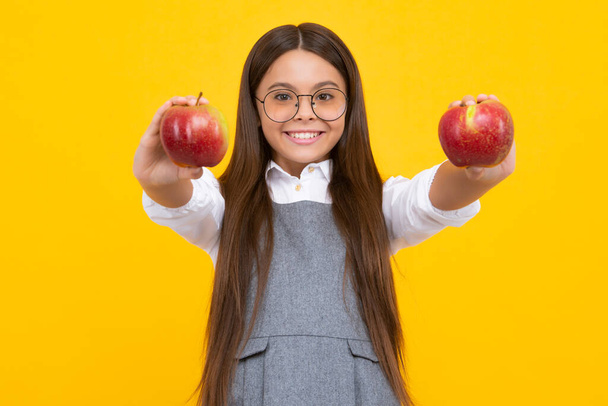 Tuoreita hedelmiä. Teini-ikäinen tyttö pitää omenoita keltainen eristetty studio tausta. Lastenravitsemus. Onnellinen tyttö kasvot, positiivisia ja hymyileviä tunteita - Valokuva, kuva