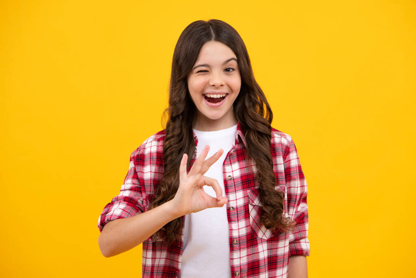 Okay. Funny teen child over yellow background doing ok gesture with hand smiling with happy face. Happy teenager, positive and smiling emotions of teen girl - Foto, Bild