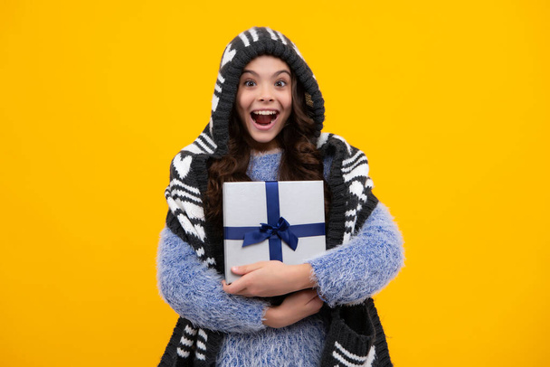 Teenager child in winter wear holding gift boxes celebrating happy New Year or Christmas. Winter kids holiday. Happy teenager, positive and smiling emotions of teen girl - Fotografie, Obrázek