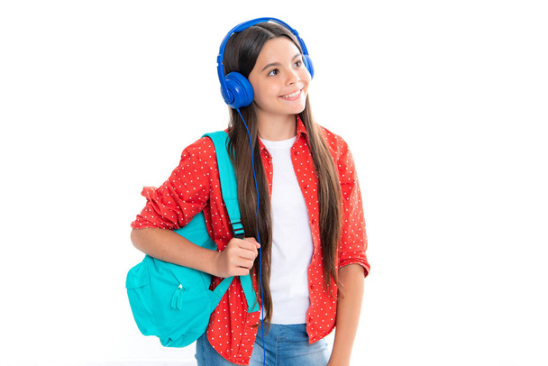 Egy iskoláslány hátizsákkal készen áll a tanulásra. Iskolás gyerekek iskolatáskával, elszigetelt fehér stúdió háttérrel. Egy boldog, mosolygós tinédzser lány portréja - Fotó, kép