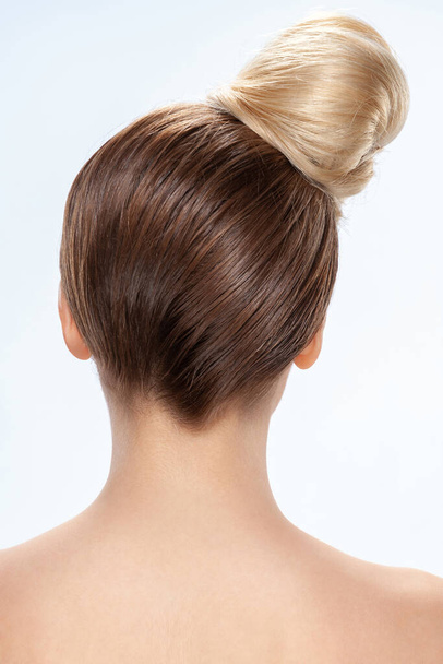 Back view of young woman. Nude young white woman. Light hair. Stylish hairdo. Isolated on a gray background - Photo, image