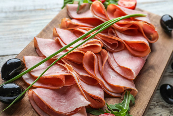 Board with slices of delicious ham on light wooden background, closeup - Photo, Image