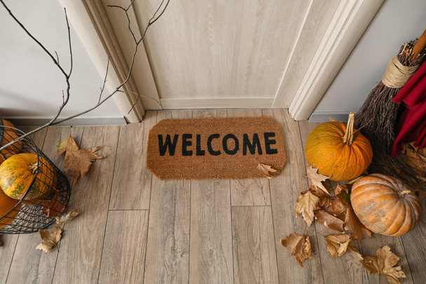 Tapete de porta com abóboras de Halloween e folhas caídas no corredor - Foto, Imagem