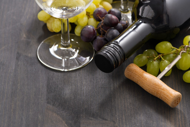 botella de vino tinto y uvas sobre un fondo de madera, primer plano
 - Foto, Imagen