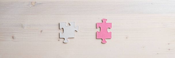 Weitwinkelbild von zwei zusammenpassenden Puzzleteilen, platziert über Holzhintergrund mit Kopierraum - Foto, Bild