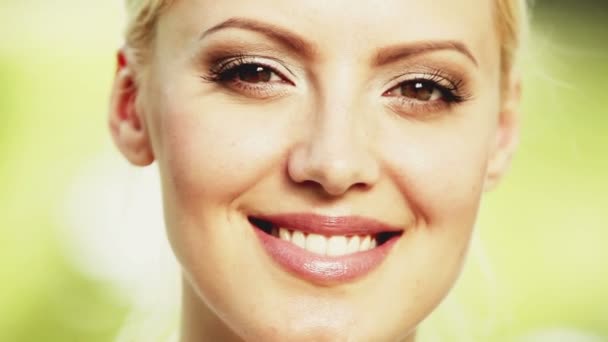 Attractive blonde young woman smiles into the camera. Close up shot. - Footage, Video