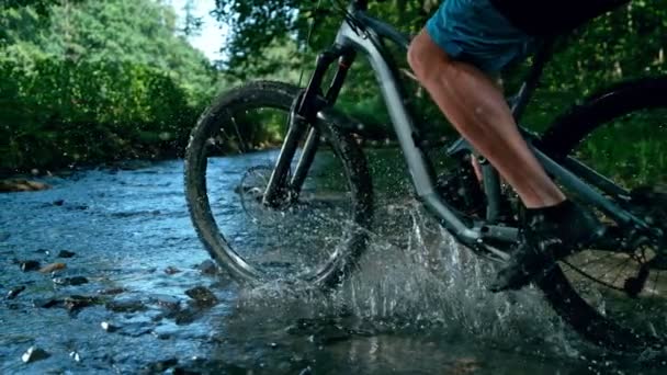 Super Slow Motion Detailaufnahme eines Mannes auf einem Mountainbike, der den Fluss mit 1000 fps überquert. Mit High-Speed-Kinokamera in 4K gefilmt. - Filmmaterial, Video