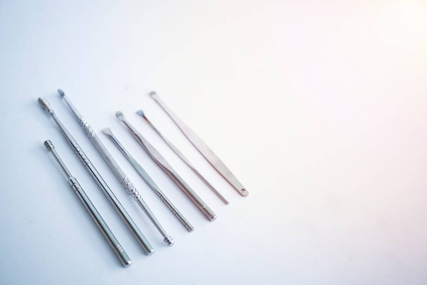 Set d'outils pour nettoyer les oreilles isolées sur fond blanc. ensemble d'outils de nettoyage d'oreille en acier inoxydable. - Photo, image