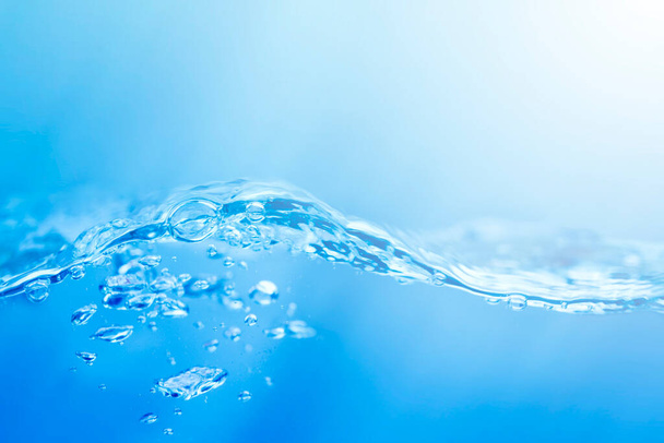 kék és fehér sima gradiens hullámokkal a felszínen a tiszta víz, mint például a tenger vagy akvárium háttér textúra. - Fotó, kép