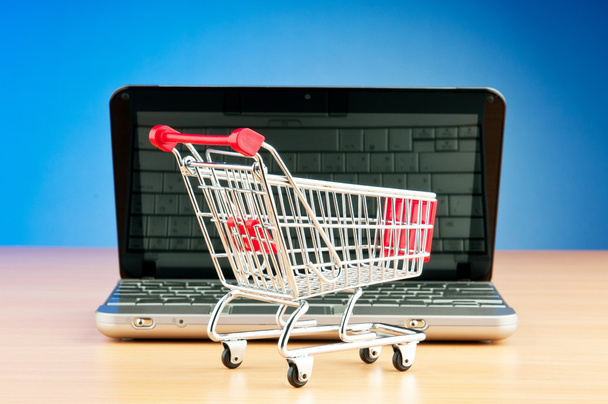Internet online shopping concept with computer and cart - Foto, imagen